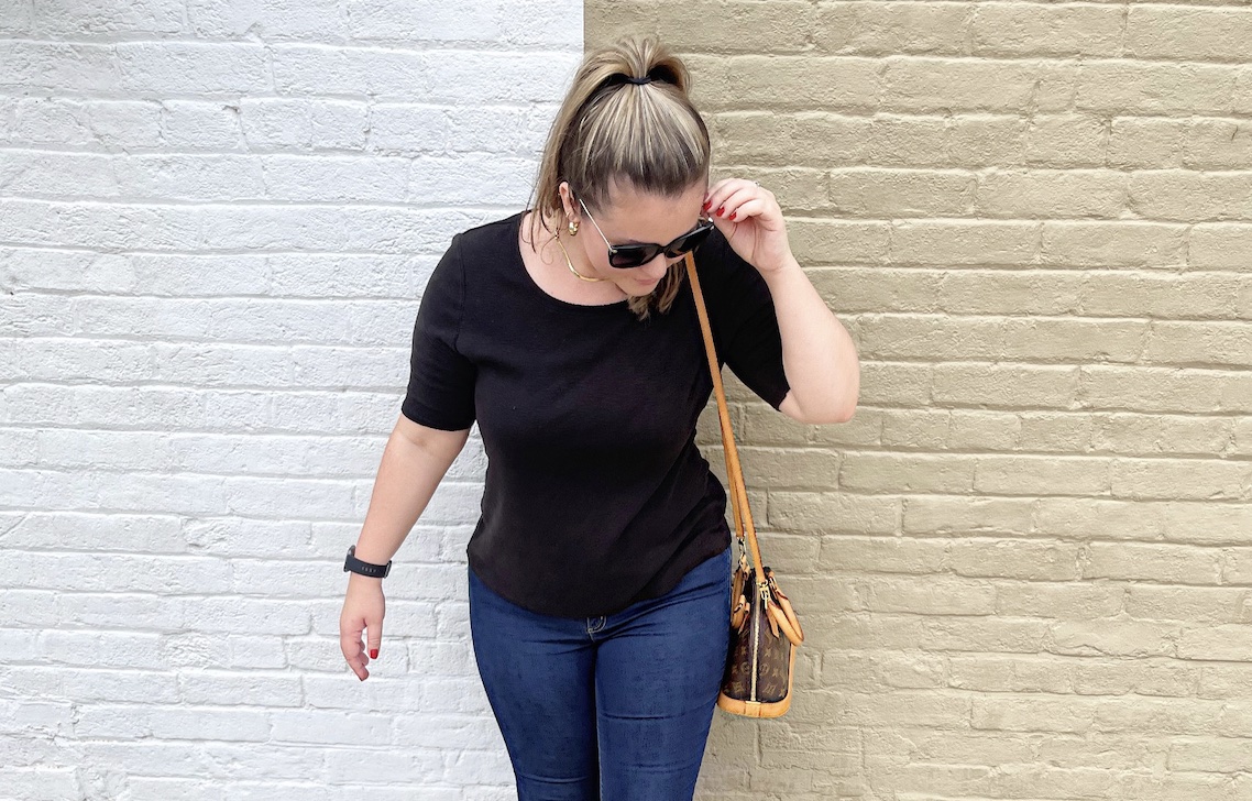 girl standing in front of white and brown brick wall